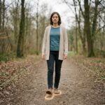 Anna setzt achtsam und langsam einen Fuß auf einen friedlichen Parkweg, der Boden leuchtet leicht auf.